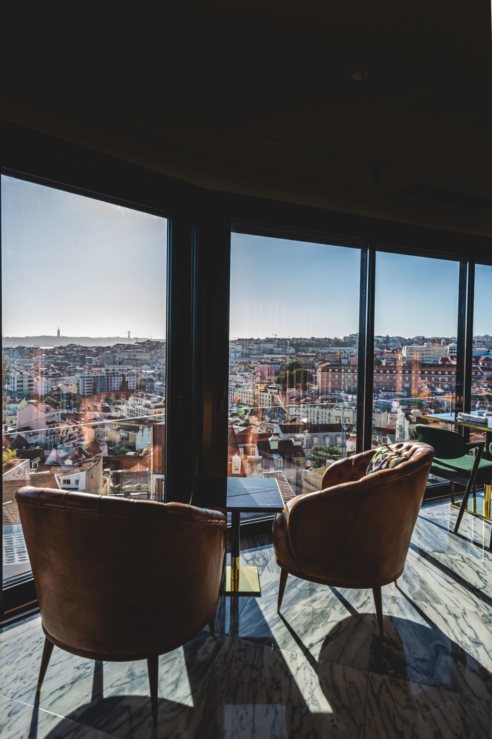 Sala com dois cadeirões, de frente a janela com vista para a cidade de Lisboa