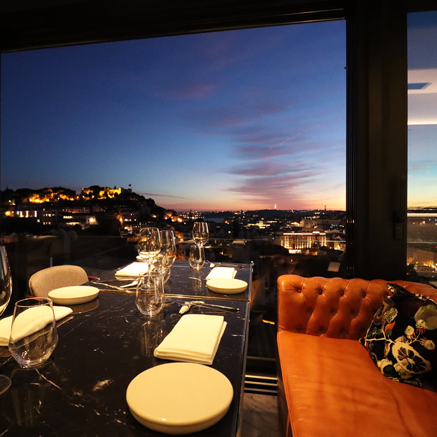 interior of the restaurant, overlooking the city of Lisbon at night